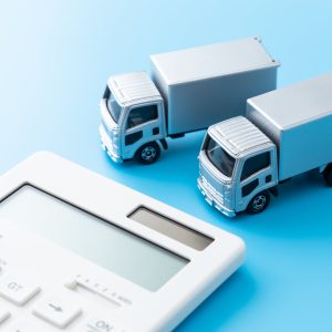 Model HGV trucks beside calculator